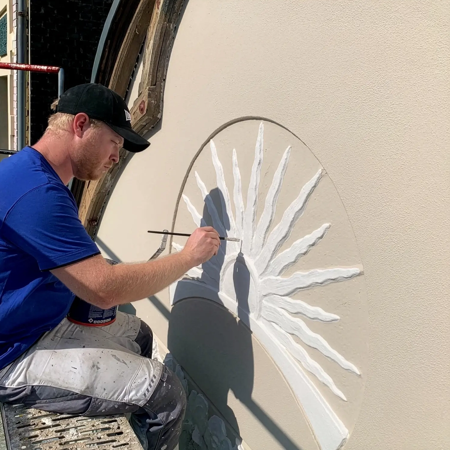 Ein Mitarbeiter von Malermeister Kleinau bei handwerklicher Detailarbeit an historischer Fassade – Jobs und Ausbildung als Maler in Düsseldorf im traditionellen Malerhandwerk.