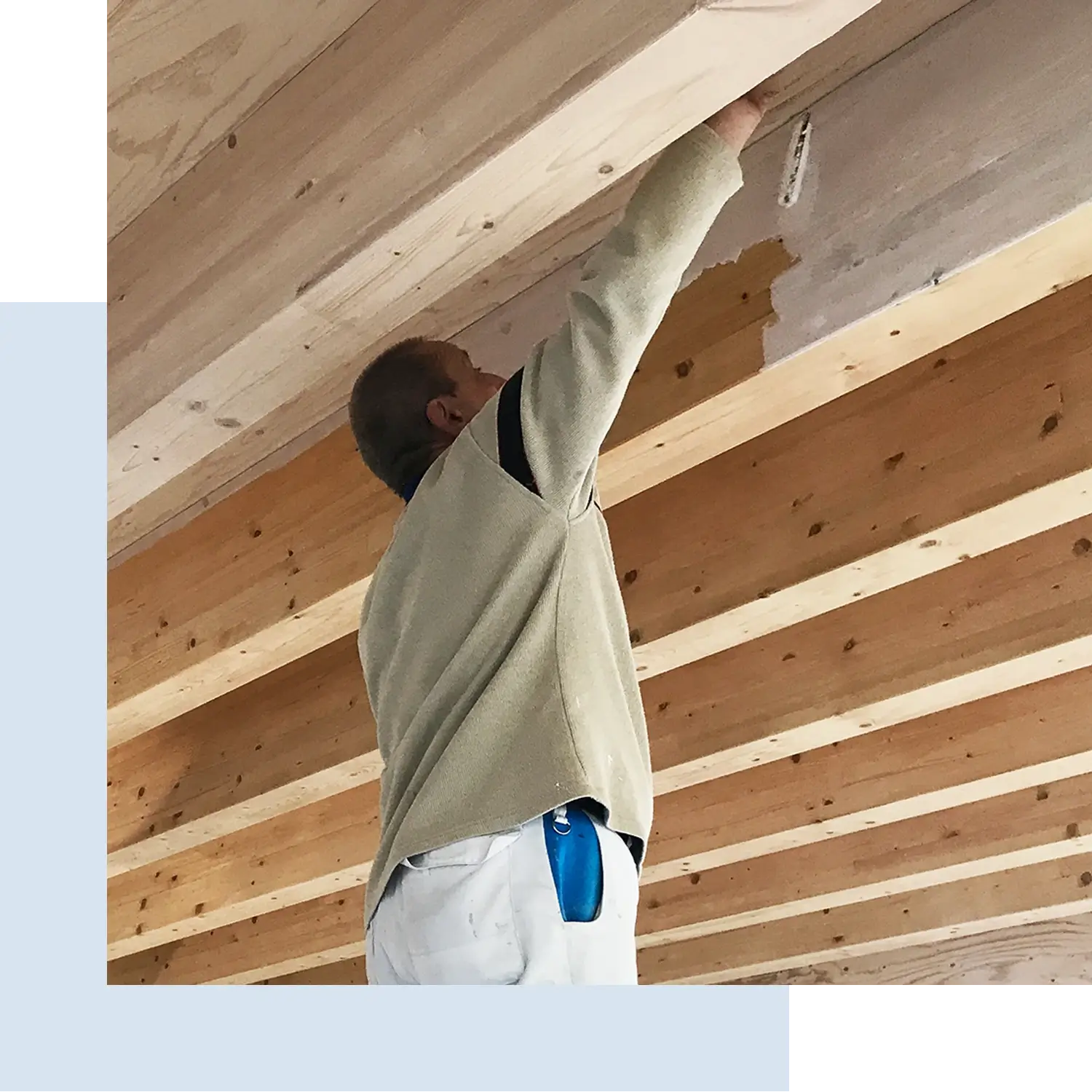 Maler bei der Bearbeitung und Oberflächenbehandlung einer Holzbalkendecke als Teil fachgerechter Lackierarbeiten in Düsseldorf durch Malermeister Kleinau