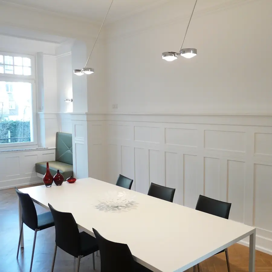Moderner Innenraum mit weißer Wandgestaltung und Stuckarbeiten, ausgeführt von Malermeister Kleinau – Kleinau Malermeister in Düsseldorf.