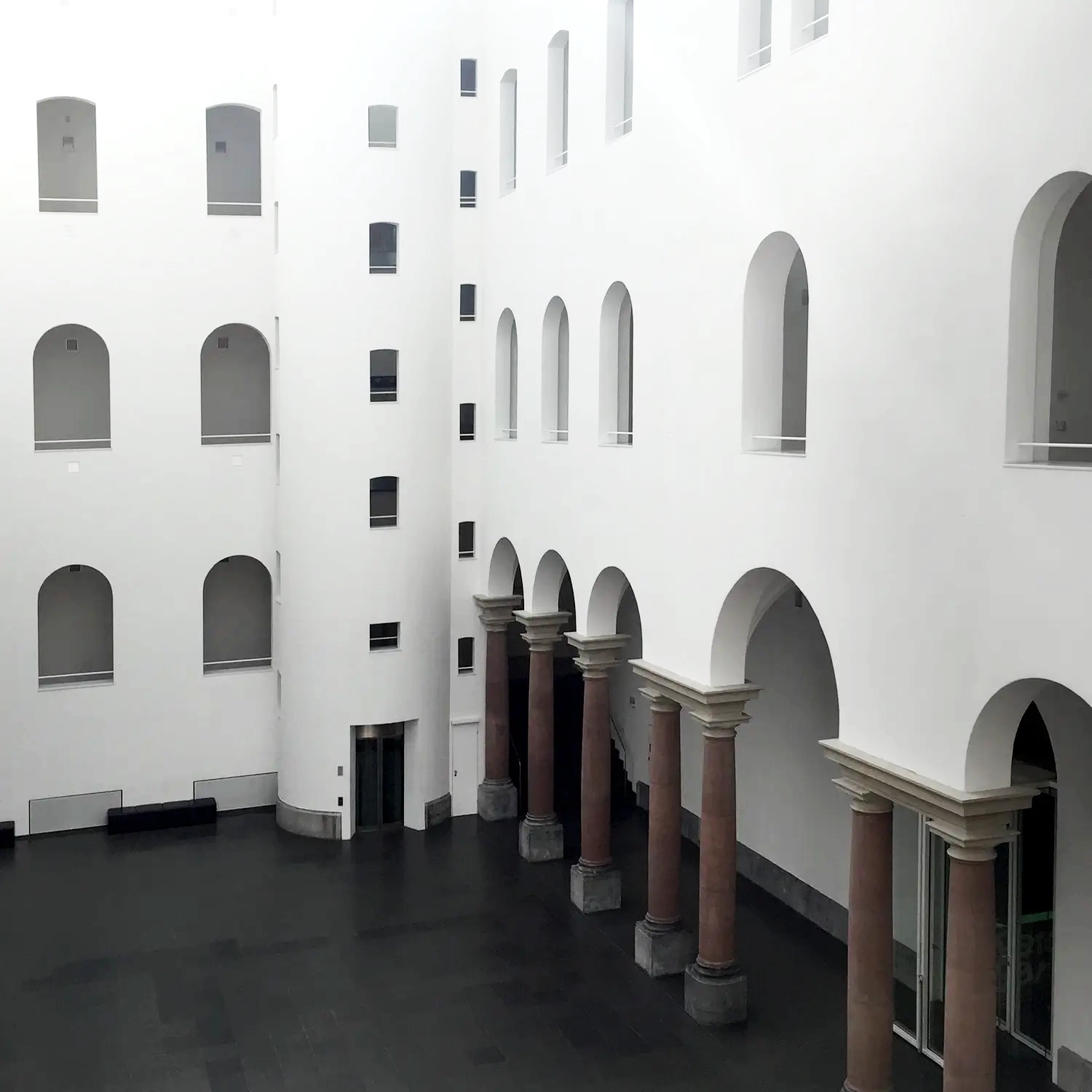 Heller, modern gestalteter Innenhof eines öffentlichen Gebäudes nach Malerarbeiten von Malermeister Kleinau – Kleinau Malermeister in Düsseldorf.
