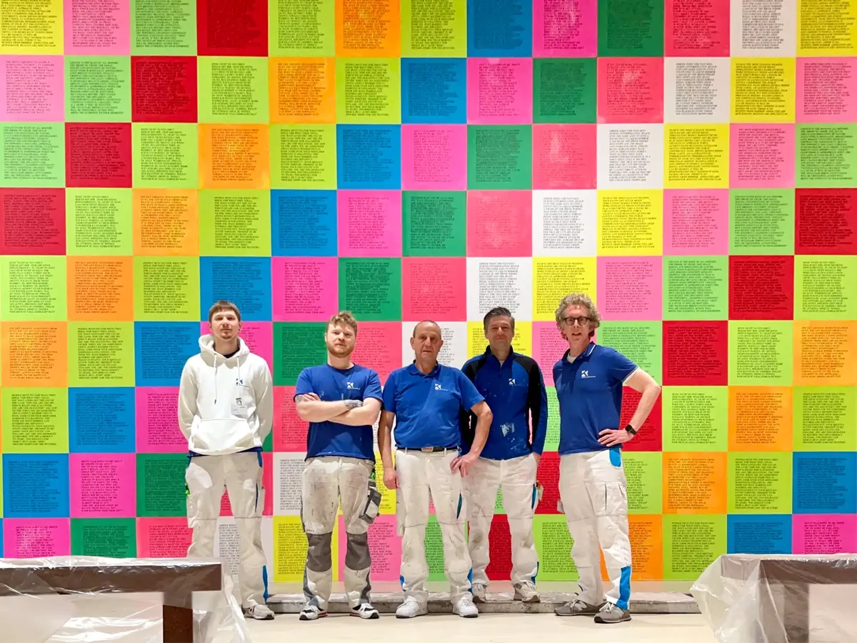 Das Kleinau Team vor bunten Tapezierarbieten für eine Ausstellung im Museum K21 Düsseldorf