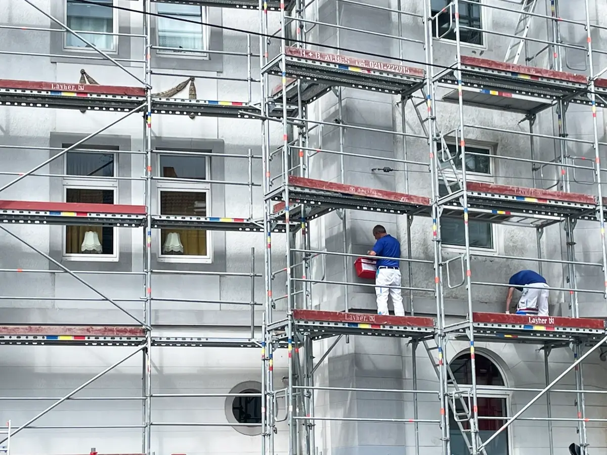 Fassadenarbeiten am Gerüst mit Malerteam bei der Sanierung eines Wohngebäudes in Düsseldorf